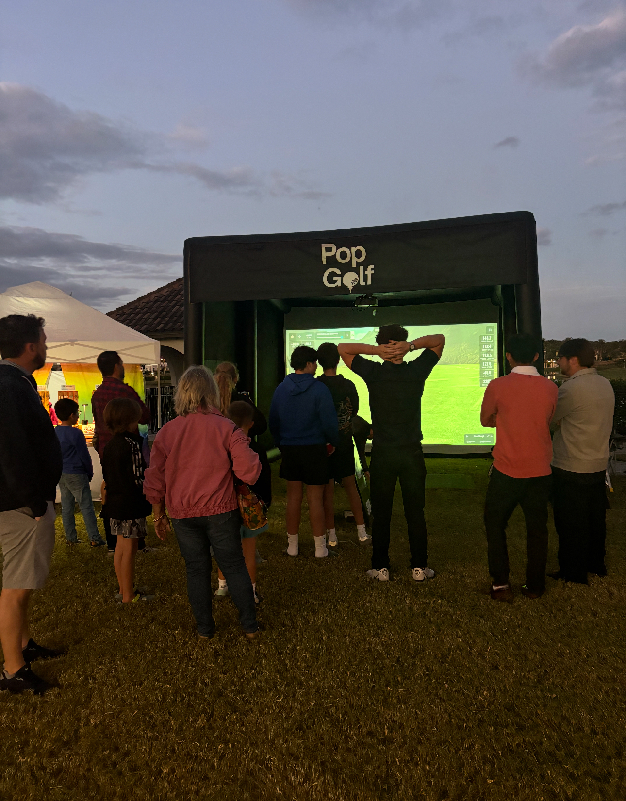 Crowd of guests watching a player at a PopGolf activation during a community evening event